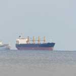 Zwei Handelsschiffe warten auf die Erlaubnis zur Einfahrt in den Hafen von Malaga.