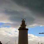 Der Leuchtturm von Malaga unter Wolken bedecktem Himmel.